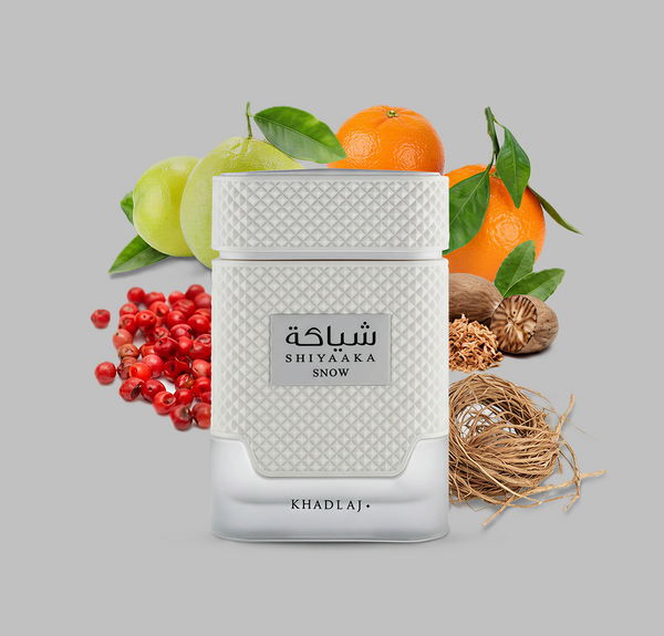 Khadlaj Shiyaaka Snow perfume bottle with fruits and natural elements on a gray background