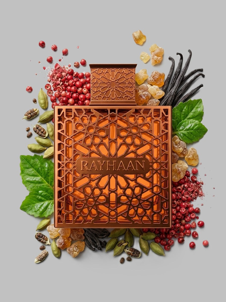 A square fragrance bottle with an ornate geometric cutout design and the brand name RAYHAAN Vantage on the front, styled on a light gray background with botanical and spice props including green leaves, red berries, vanilla pods, and candied fruit.