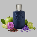 Parfum de Marly Layton Blue perfume bottle with silver cap surrounded by green apples, purple flowers, and a lime on a gray background